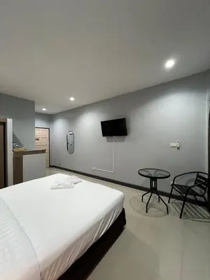 a bedroom with a bed and a tv on the wall at PMS Guest House Patong in Patong Beach