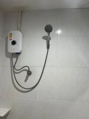 a shower with a hose attached to a wall at PMS Guest House Patong in Patong Beach