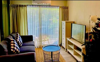 a living room with a couch and a television at naiyang beach in Phuket