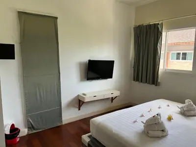 a bedroom with a bed and a flat screen tv at Kata beach at pool house in Kata Beach