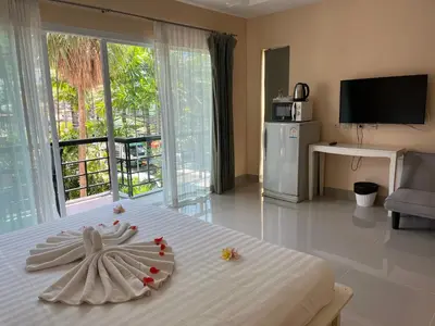 a bedroom with a white bed with a flower on it at Kata beach at pool house in Kata Beach