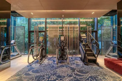 a gym with treadmills and elliptical machines on a blue carpet at 1BR Designer Mountain View Condo - Central Phuket in Phuket Town