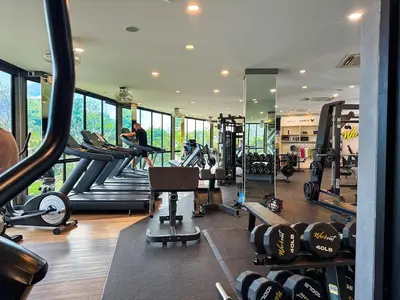 a gym with tread machines and a man on a treadmill at Kamala City Gate 1 Bdr Pool View in Kamala Beach