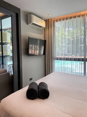 a bedroom with a bed with two black towels on it at Kamala City Gate 1 Bdr Pool View in Kamala Beach
