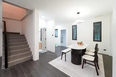 a living room with a table and chairs and stairs at Stylish 3 Bedroom Villa with Garden, Chalong - by PoshSaga in Chalong