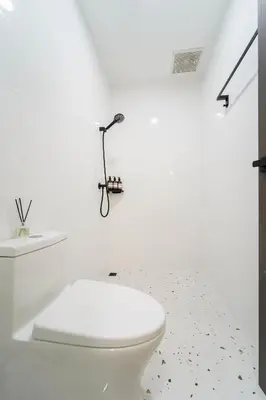 a white bathroom with a toilet and a white wall at Stylish 3 Bedroom Villa with Garden, Chalong - by PoshSaga in Chalong