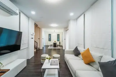 a living room with a couch and a tv at Stylish 3 Bedroom Villa with Garden, Chalong - by PoshSaga in Chalong