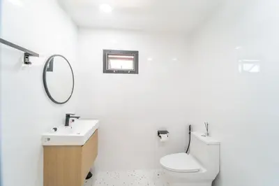 a white bathroom with a toilet and a sink at Stylish 3 Bedroom Villa with Garden, Chalong - by PoshSaga in Chalong