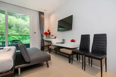 a living room with a dining room table and chairs at Private apartment at Emerald Terrace by Lofty in Patong Beach