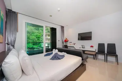 a bedroom with a white bed and a living room at Private apartment at Emerald Terrace by Lofty in Patong Beach