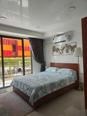 a bedroom with a bed and a large window at Уютная студия в жилом комплексе в заповедном уголке Пхукета in Ban Mai Salae