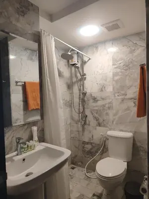 a bathroom with a white toilet and a sink at Уютная студия в жилом комплексе в заповедном уголке Пхукета in Ban Mai Salae
