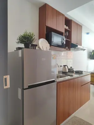 a kitchen with a stainless steel refrigerator and a microwave at Уютная студия в жилом комплексе в заповедном уголке Пхукета in Ban Mai Salae