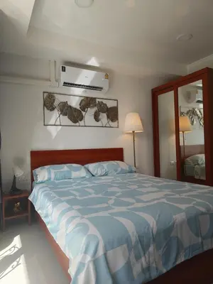 a bedroom with a bed with a blue comforter at Уютная студия в жилом комплексе в заповедном уголке Пхукета in Ban Mai Salae