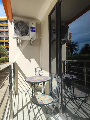 two chairs and a table on a balcony with a heater at Уютная студия в жилом комплексе в заповедном уголке Пхукета in Ban Mai Salae