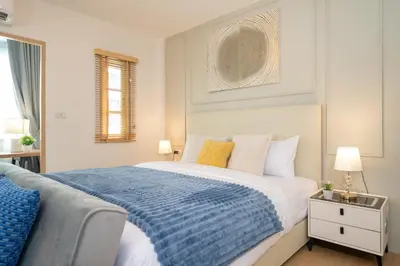 a bedroom with a large bed with a blue blanket at 2Rooms apartment in Bangla Patong in Patong Beach