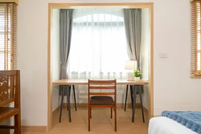 a bedroom with a table and a chair in front of a window at 2Rooms apartment in Bangla Patong in Patong Beach