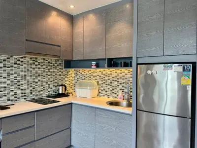 a kitchen with gray cabinets and a stainless steel refrigerator at Room in Kamala at Citygate Condo in Kamala Beach