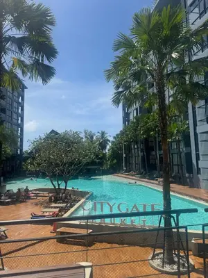 a swimming pool in a city with palm trees at Room in Kamala at Citygate Condo in Kamala Beach