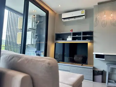 a living room with a couch and a large window at Room in Kamala at Citygate Condo in Kamala Beach