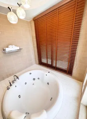 a white bath tub in a bathroom with a window at La Nissta Villa 4bdr pool Villa Phuket in Koh Lone