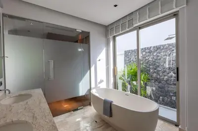 a bathroom with a tub and a sink and a window at Botanica Foresta x MonthStayZ Thailand in Bang Tao Beach