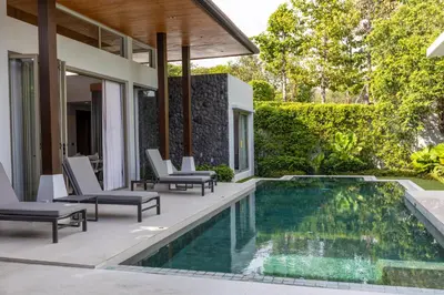 an outdoor patio with chairs and a swimming pool at Botanica Foresta x MonthStayZ Thailand in Bang Tao Beach