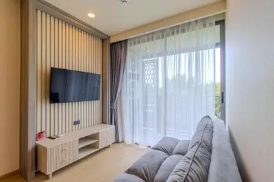 a living room with a couch and a large window at C240 New Prime Location 1BR Condo Near Beach Club in Thalang