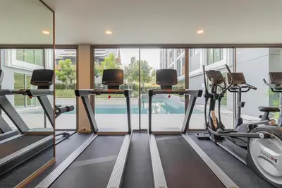 a gym with treadmills and ellipticals in a building at C240 New Prime Location 1BR Condo Near Beach Club in Thalang