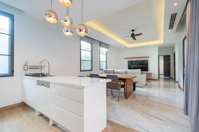 a kitchen with white cabinets and a dining room at Nicky Villa Luxury Private Haven in BangTao Laguna in Laguna Phuket