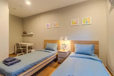 a bedroom with two beds and a table with a lamp at C241 2BR Pool Access 5 Min Walk to Rawai Beach in Rawai Beach