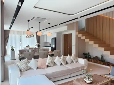a living room with a white couch with pillows at The Eden Hill in Phuket Town