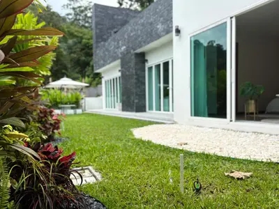 a house with a yard with green grass at The Eden Hill in Phuket Town