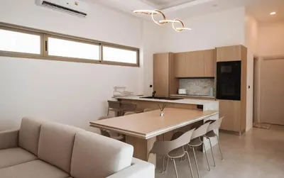 a kitchen with a table and chairs in a room at Вилла в поселке БанБуа in Rawai Beach