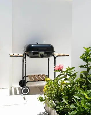 a grill sitting on a table next to some plants at Вилла в поселке БанБуа in Rawai Beach