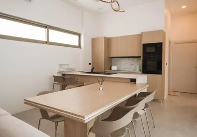 a kitchen with a wooden table and chairs at Вилла в поселке БанБуа in Rawai Beach