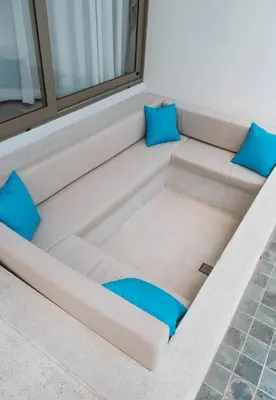 a couch in a room with blue pillows at Вилла в поселке БанБуа in Rawai Beach