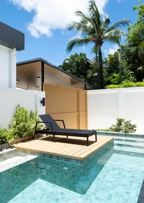 a villa with a pool and a chair on a deck at Вилла в поселке БанБуа in Rawai Beach