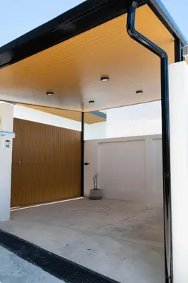 an open garage with a door and a building at Вилла в поселке БанБуа in Rawai Beach