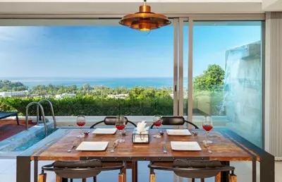 a dining room with a table with wine glasses at Luxury Penthouse with Private Pool at View Phuket F9 in Karon Beach