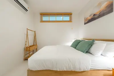 a bedroom with a white bed and a window at Nai Harn Beach Holiday Home - Rawai 4bdr in Rawai Beach