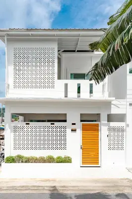 a white house with a orange door at Nai Harn Beach Holiday Home - Rawai 4bdr in Rawai Beach