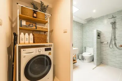 a washing machine in a bathroom with a shower at Nai Harn Beach Holiday Home - Rawai 4bdr in Rawai Beach