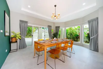 a dining room with a wooden table and chairs at Exclusive & Private! Elegant Two-Storey Pool Villa Anong in Kamala in Kamala Beach