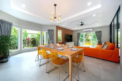 a dining room with a table and yellow chairs at Exclusive & Private! Elegant Two-Storey Pool Villa Anong in Kamala in Kamala Beach