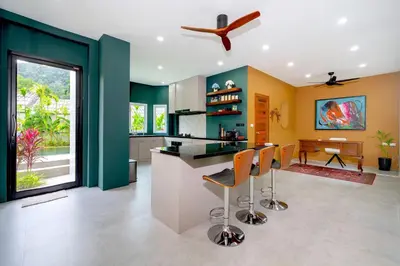 a kitchen with green and yellow walls and a counter with stools at Exclusive & Private! Elegant Two-Storey Pool Villa Anong in Kamala in Kamala Beach