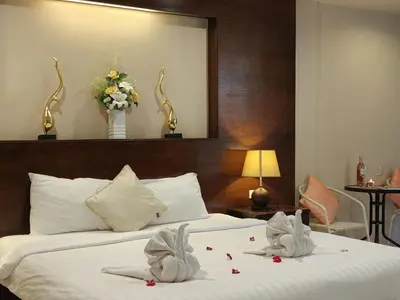 a hotel room with two beds with towels on them at Purimas Resortel in Rawai Beach