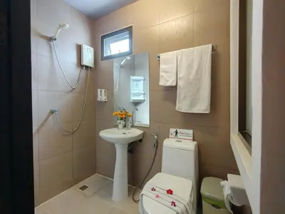 a small bathroom with a toilet and a sink at Purimas Resortel in Rawai Beach