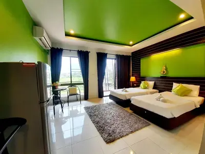 a room with two beds and a green wall at Purimas Resortel in Rawai Beach