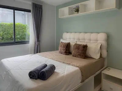a bedroom with a white bed with two pillows on it at Condo for rent chalong rawai 106 in Ban Klang